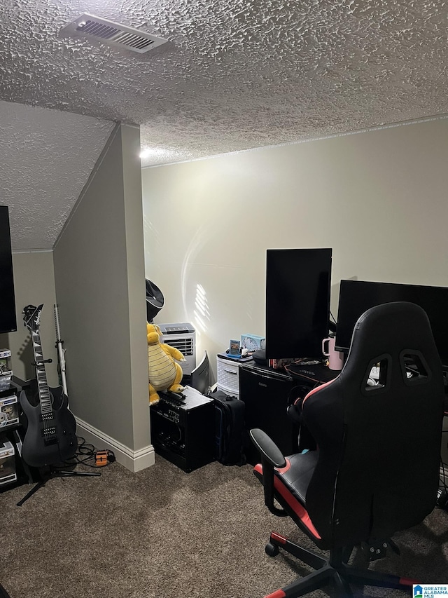 home office with visible vents, carpet floors, a textured ceiling, and baseboards