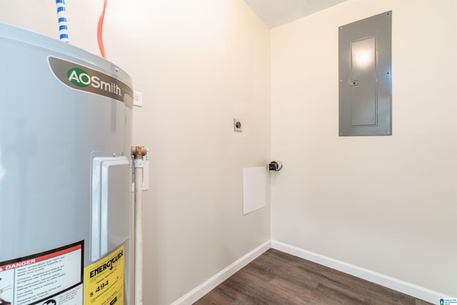 laundry area with electric panel, electric water heater, dark wood-style floors, baseboards, and laundry area