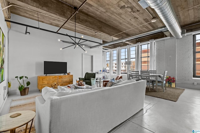 living room with a notable chandelier and concrete flooring