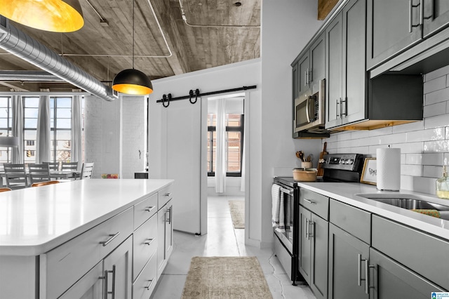 kitchen featuring stainless steel appliances, tasteful backsplash, gray cabinets, and light countertops