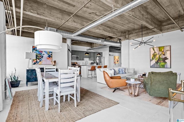 dining room featuring a chandelier and concrete floors