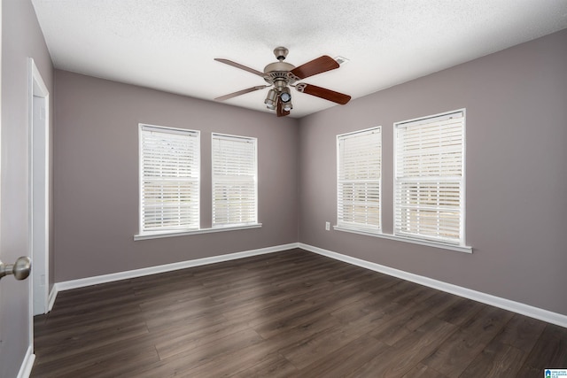 spare room with dark wood finished floors, baseboards, and a textured ceiling