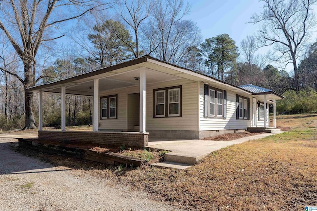 view of front of home featuring crawl space, metal roof, and driveway