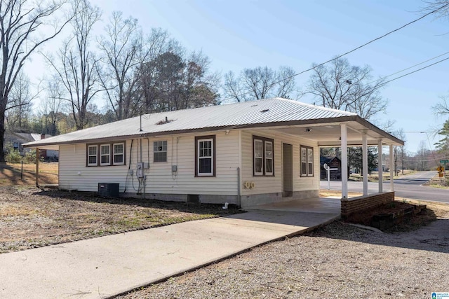 view of front of house featuring crawl space, metal roof, an attached carport, and driveway