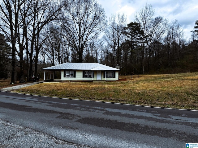 view of front of property with an attached carport, a front lawn, and driveway