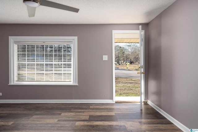 interior space featuring baseboards, a textured ceiling, wood finished floors, and a ceiling fan