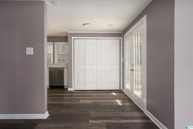 interior space with access to outside, a textured ceiling, dark wood-style floors, a closet, and baseboards