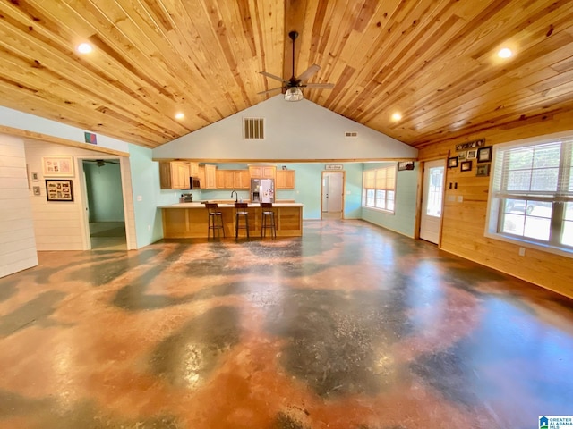 interior space featuring visible vents, open floor plan, wood ceiling, vaulted ceiling, and stainless steel refrigerator with ice dispenser