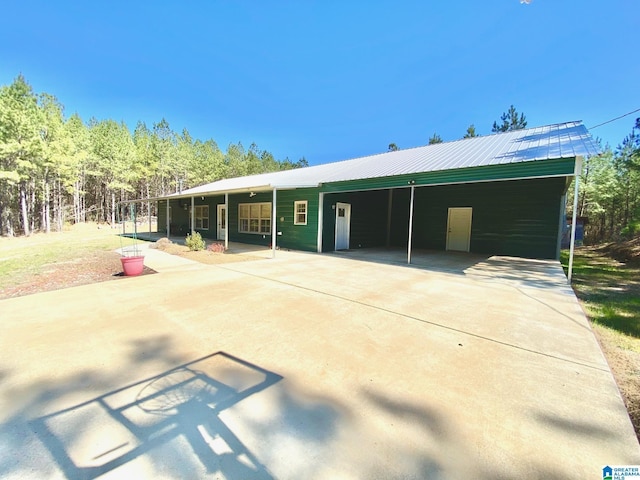 view of front of property with an attached carport, driveway, and metal roof