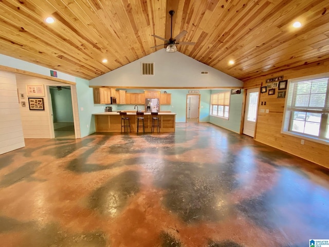 interior space featuring visible vents, a peninsula, finished concrete floors, stainless steel appliances, and wooden ceiling