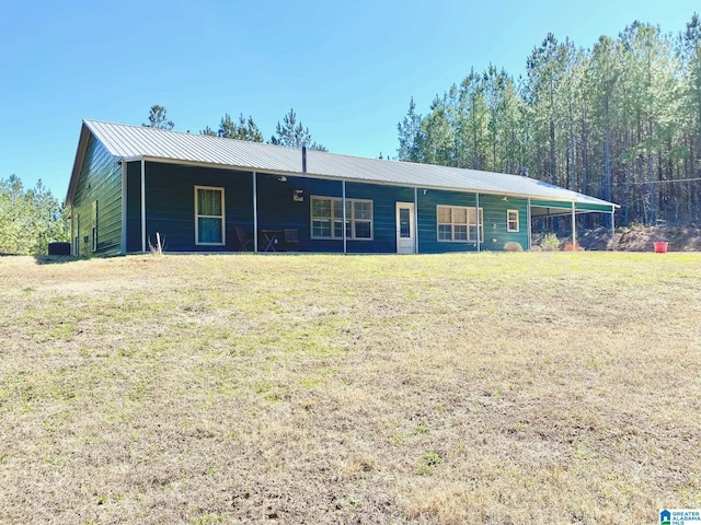 view of front of property featuring metal roof and a front lawn