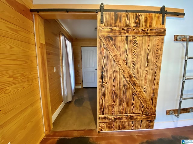 hall with a barn door and wood walls