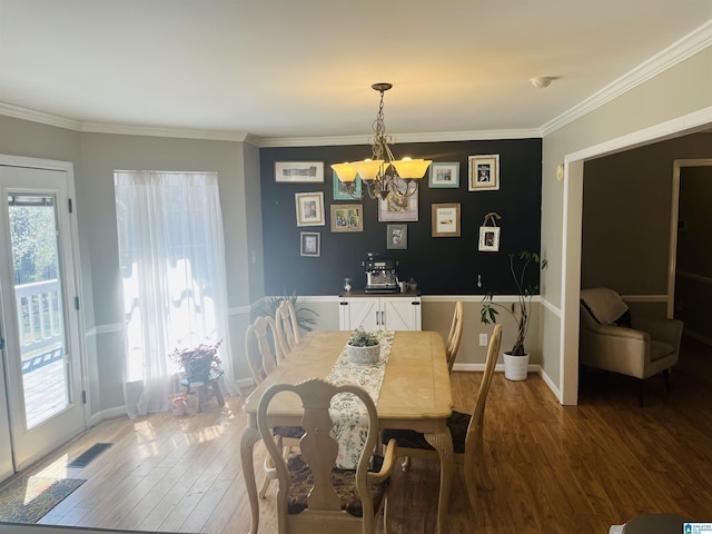 dining area with crown molding, wood finished floors, visible vents, and baseboards