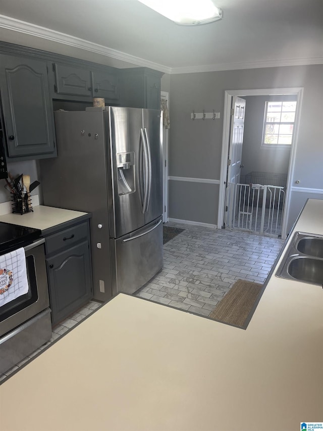 kitchen featuring a sink, appliances with stainless steel finishes, ornamental molding, and light countertops