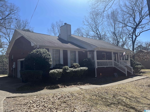 view of side of property with a porch and a chimney