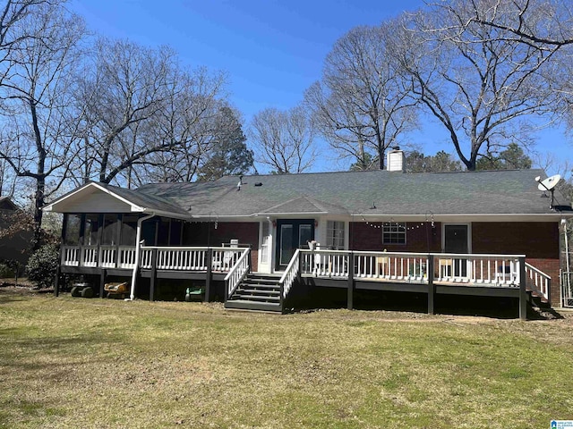 rear view of property featuring brick siding, a lawn, a chimney, and a sunroom