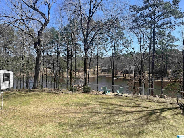 view of yard featuring fence and a water view