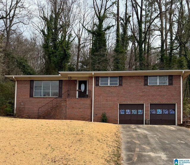 view of front of property with brick siding, crawl space, driveway, and a garage