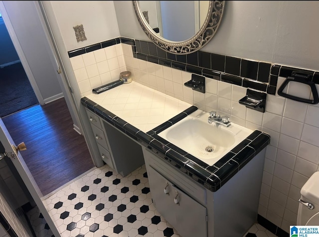 bathroom with vanity and tile walls