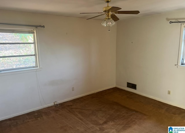 empty room featuring baseboards, visible vents, a ceiling fan, and carpet