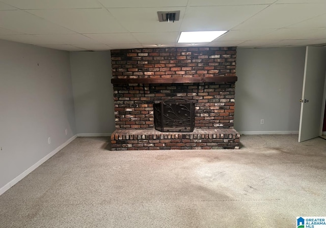 unfurnished living room with a paneled ceiling, visible vents, carpet floors, and baseboards