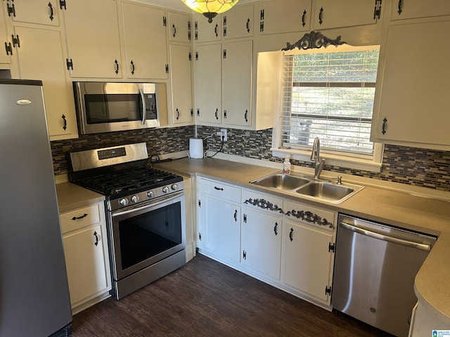 kitchen featuring a sink, stainless steel appliances, dark wood-type flooring, light countertops, and tasteful backsplash