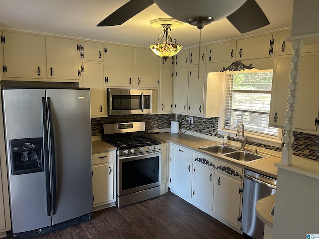 kitchen with a sink, tasteful backsplash, stainless steel appliances, light countertops, and dark wood-style flooring