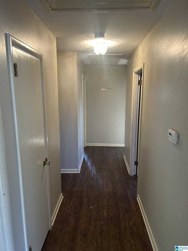 hall featuring attic access, baseboards, and wood finished floors