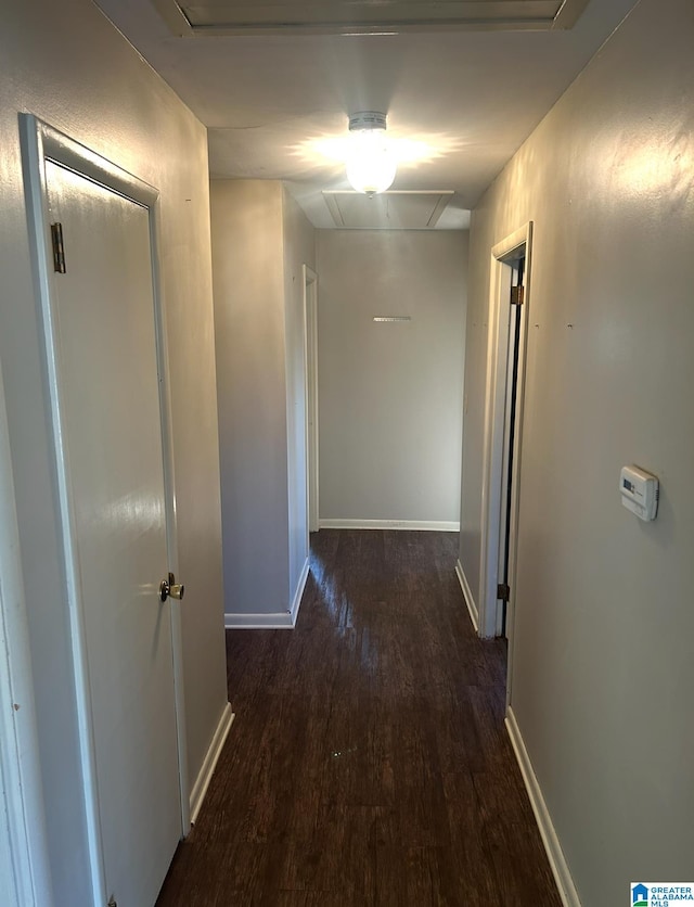 corridor featuring baseboards and wood finished floors