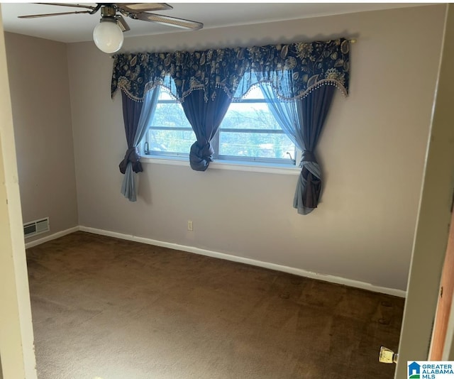 carpeted empty room with visible vents, ceiling fan, and baseboards