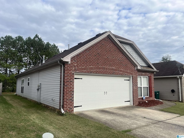 view of side of home with a yard, brick siding, an attached garage, and driveway