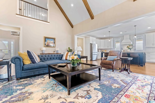 living room featuring recessed lighting, beamed ceiling, light wood-style floors, and high vaulted ceiling