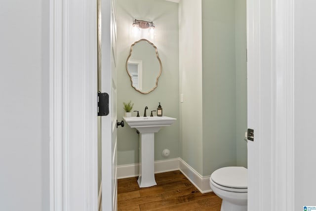 bathroom featuring toilet, baseboards, and wood finished floors