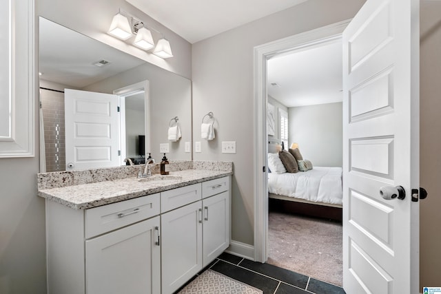 bathroom with visible vents, baseboards, vanity, tile patterned floors, and ensuite bath