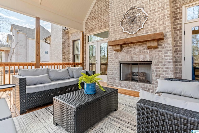 exterior space featuring an outdoor brick fireplace, crown molding, lofted ceiling, and wood finished floors