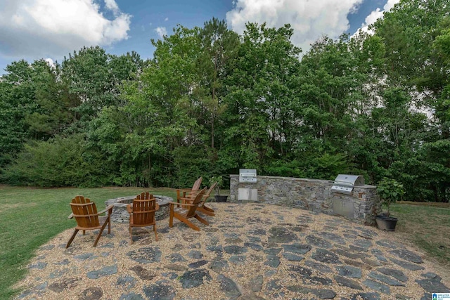 view of patio / terrace featuring grilling area, a fire pit, and exterior kitchen