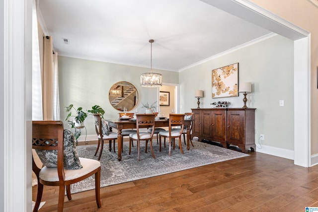 dining area with baseboards, wood-type flooring, and crown molding