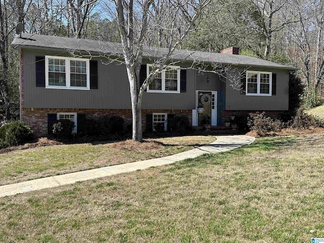 bi-level home featuring a chimney and a front lawn