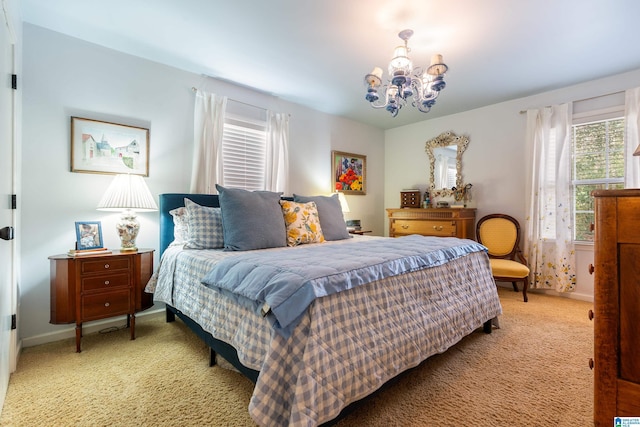 carpeted bedroom with baseboards and an inviting chandelier