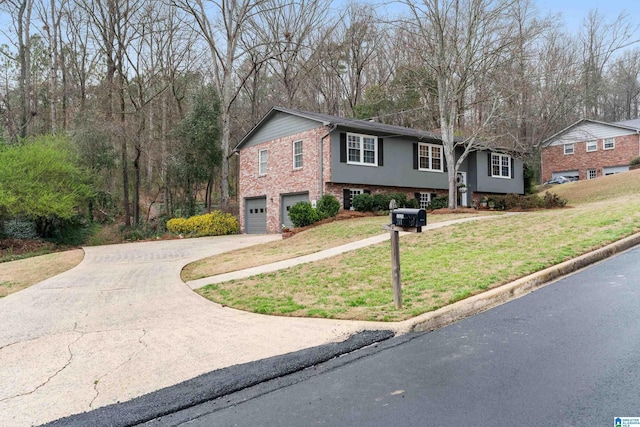 raised ranch featuring brick siding, an attached garage, concrete driveway, and a front lawn