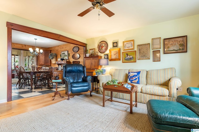 living room featuring wood finished floors and ceiling fan with notable chandelier