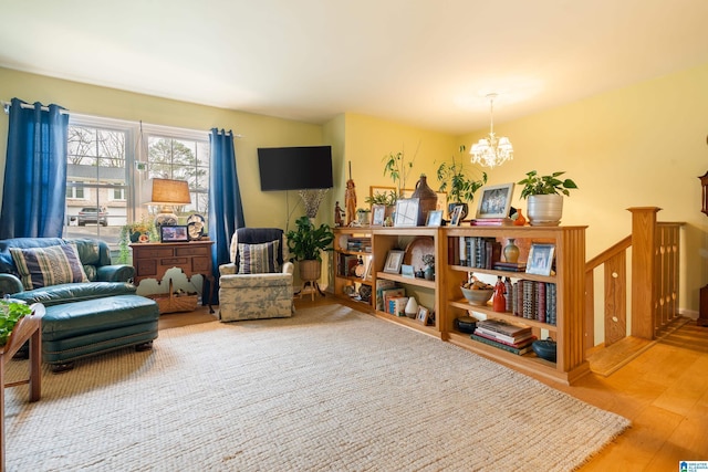 sitting room with stairway, an inviting chandelier, and wood finished floors