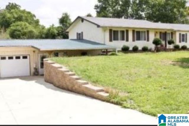 ranch-style home featuring a front yard, an attached garage, and driveway