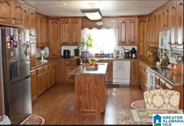 kitchen with white appliances, brown cabinets, and wood finished floors