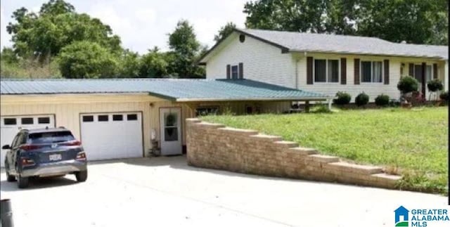 view of front facade featuring a garage, a front lawn, and driveway