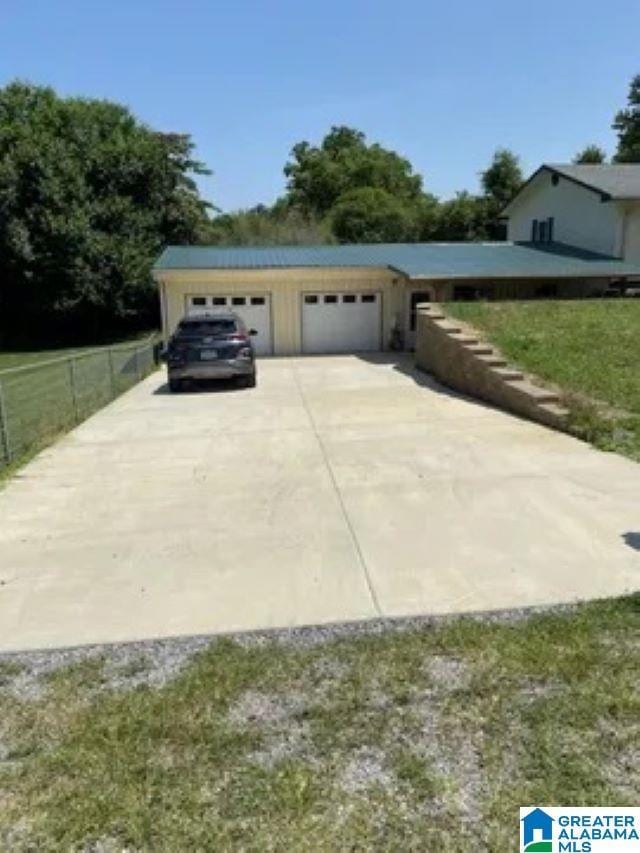 garage with driveway and fence