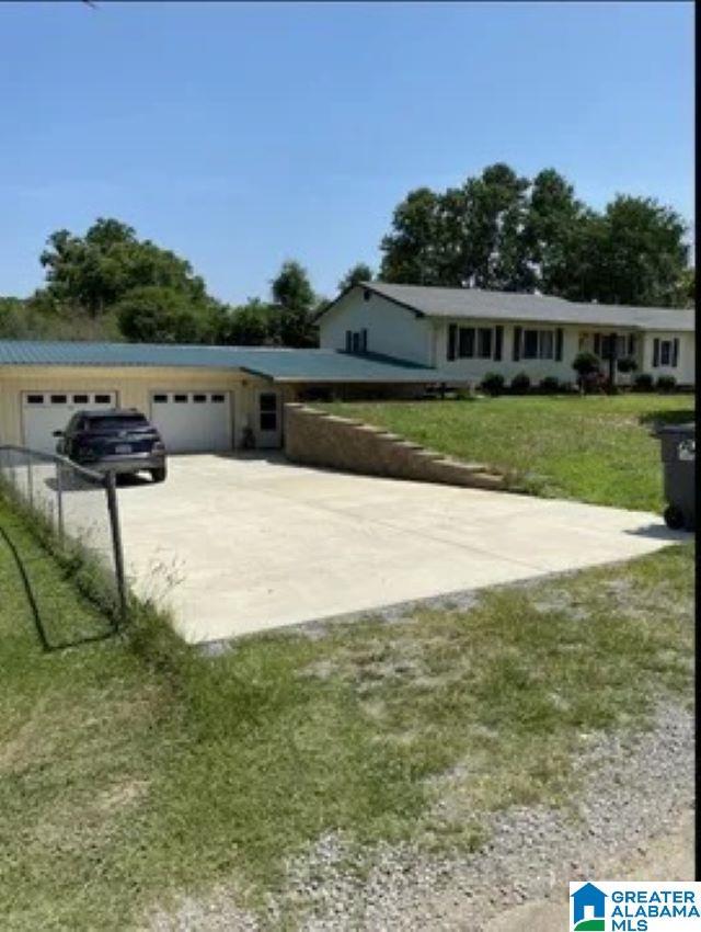 ranch-style house featuring a garage, driveway, and a front yard