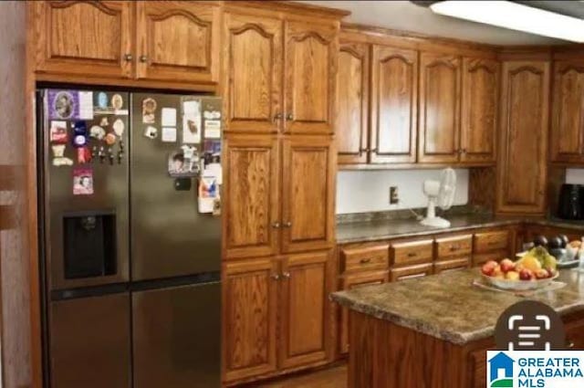 kitchen featuring brown cabinetry and stainless steel fridge with ice dispenser