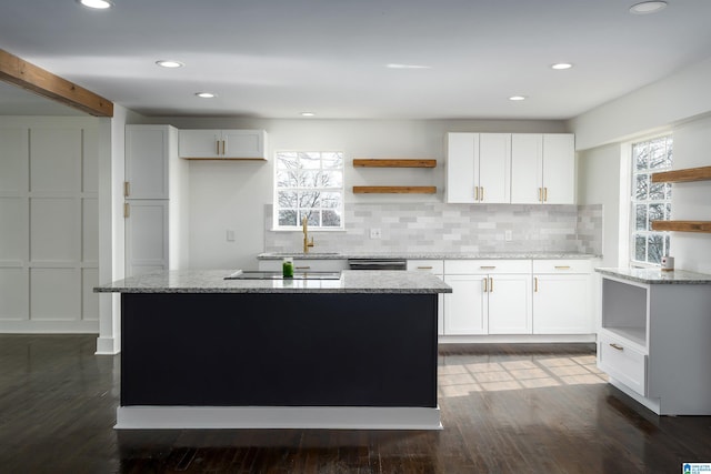 kitchen with white cabinetry, open shelves, and a kitchen island