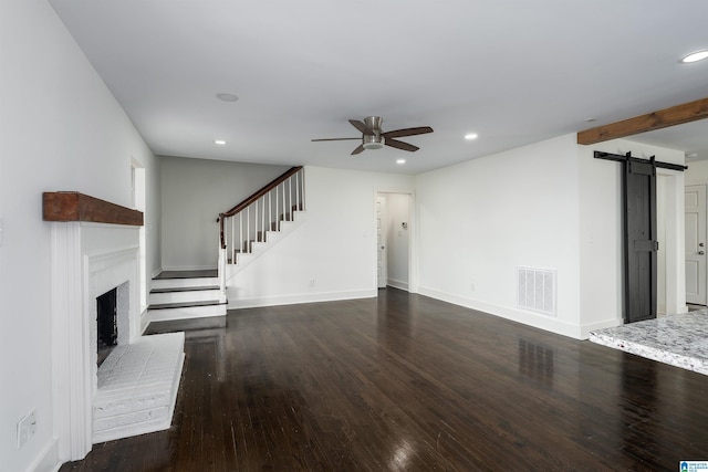 unfurnished living room featuring visible vents, stairway, a barn door, recessed lighting, and wood finished floors